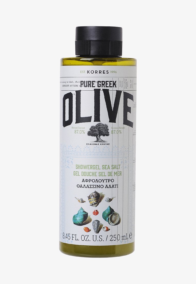 Grön och vit flaska med Pure Greek Olive duschgel, med ett svart lock, märkt med produktinformation, snäckor och design av olivträd.