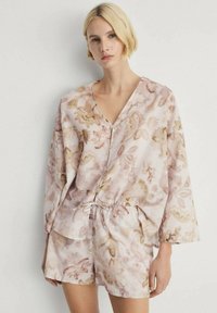 Lichtgewicht loungewear set met een bloemenpatroon in zachte roze en beige tinten. Bevat een top met V-hals en lange mouwen, evenals shorts met koordjes.