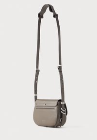 Borsa a spalla in pelle grigia con forma arrotondata, chiusura a pattina piatta, tasca con zip frontale e tracolla regolabile con dettagli in metallo argentato.