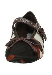 Scarpa piatta con tomaia in materiali misti nei colori crema, marrone e nero. Presenta una punta arrotondata, un fiocco decorativo e una fascia con occhielli in metallo.