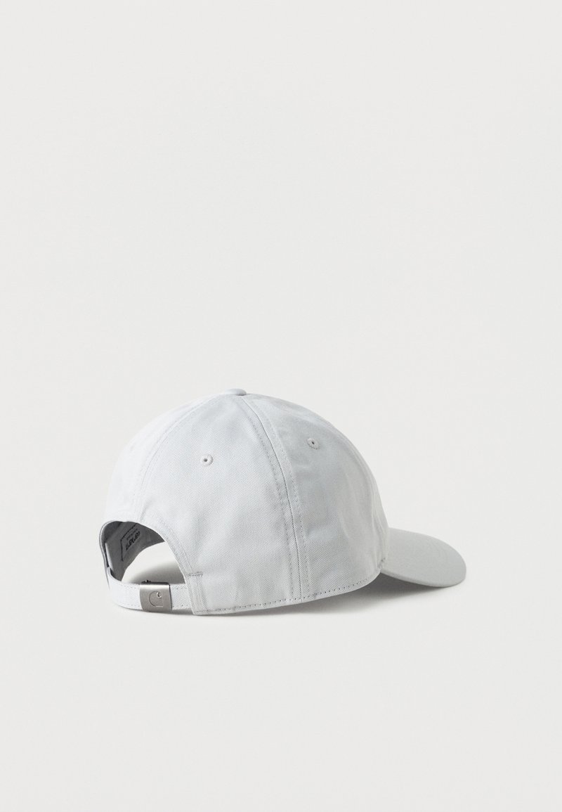 Gorra de béisbol blanca ajustable vista desde atrás, con hebilla metálica y ojales de ventilación sobre un fondo liso.