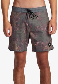 Men's swim trunks in a multicolored leaf pattern on a textured background. Features a drawstring waist and RVCA logo on the lower hem.