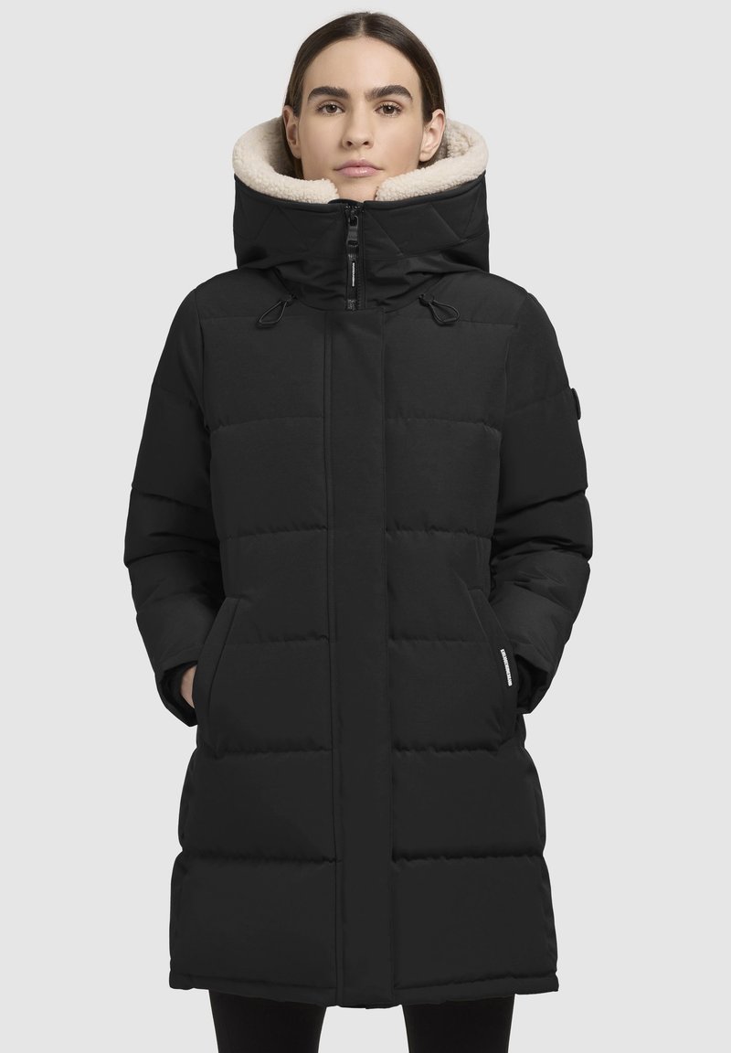 Schwarze Daunenjacke mit hohem Kragen, weicher Fütterung und Fronttaschen. Mit einem Reißverschlussverschluss und einem gesteppten Muster.