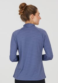 Langarm-Sportshirt in Hellblau, mit Stehkragen, strukturiertem Stoff und einer körpernahen Passform mit Raglanärmeln.