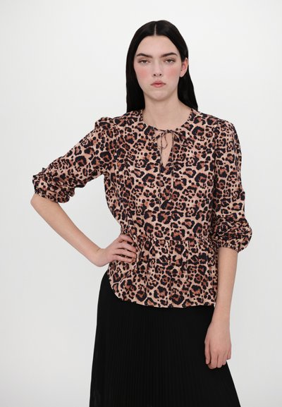 Leopard print blouse in pink and black, featuring a keyhole neckline, puffed sleeves, and a peplum waist. Fabric appears lightweight and textured.