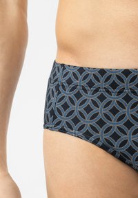 Marine zwembroek met een met elkaar verbonden ringpatroon in lichtblauw. Gemaakt van rekbare stof met een zachte textuur en een elastische tailleband.