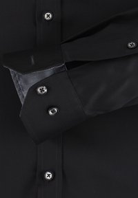 Zwarte dress shirtstof met een soepele textuur, voorzien van contrasterende blauwe gestippelde binnenmanchetten en zilveren knopen met vier gaatjes.