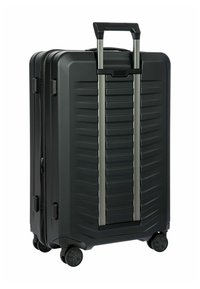 Valigia rigida nera con superficie testurizzata, manico retrattile e doppie ruote per la mobilità. Dotata di chiusura a zip e manico laterale.