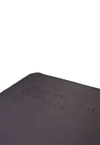 Zwarte kunstlederen oppervlakte met reliëf "nomad" logo. Gladde textuur, rechthoekige vorm, eenvoudig ontwerp, minimalistisch zonder extra patronen.