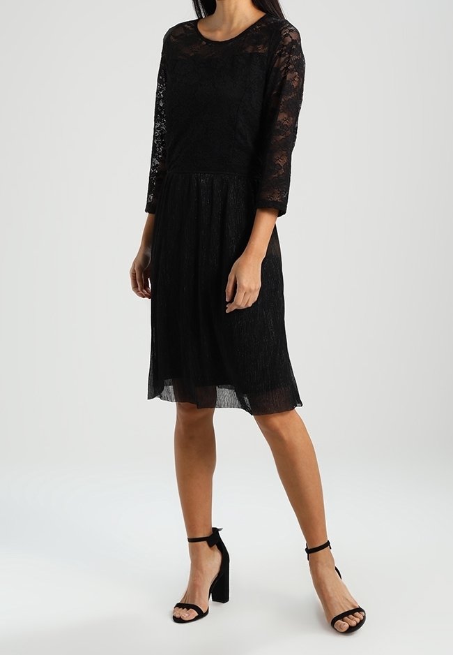 Mustapitsinen mekko, jossa on kolme neljäsosaa hihat, pyöreä pääntie ja liehuvahelma. Ominaisuuksiin kuuluu teksturoitu kangas ja polvimittainen leikkaus.