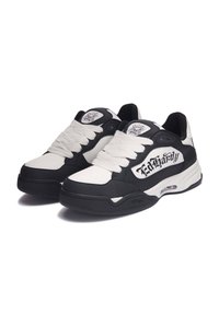 Zapatillas en blanco y negro con grandes cordones blancos, cuello acolchado, puntera perforada y un logo en el costado. Suela texturizada para un mejor agarre.