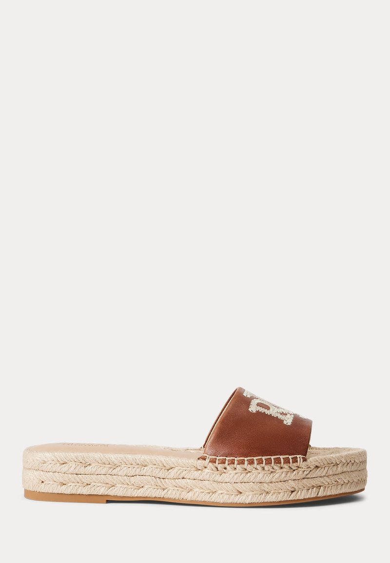 Brązowe skórzane klapki na platformie z beżową plecionką i białym haftowanym logo na pasku, widok z boku na jednolitym tle.
