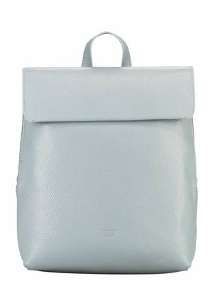Sac à dos en cuir gris clair avec rabat pliable et poignée supérieure, surface texturée lisse et logo discret embossé sur la partie inférieure centrale à l'avant.