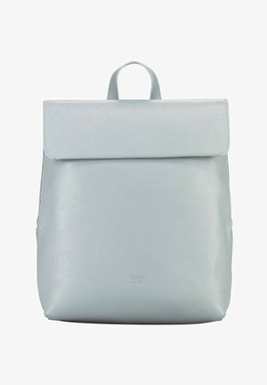 Sac à dos en cuir gris clair avec rabat pliable et poignée supérieure, surface texturée lisse et logo discret embossé sur la partie inférieure centrale à l'avant.