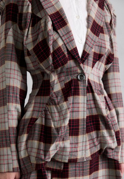 Blazer de cuadros con mangas abullonadas, cintura ajustada y un botón negro. El material presenta tonos rojos, grises y beige en un patrón a cuadros.