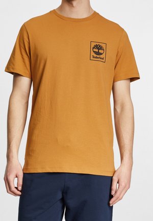 Kortærmet T-shirt med rund hals i orange bomuld med en lille sort Timberland-logo i et firkantet lommedesign på venstre bryst.