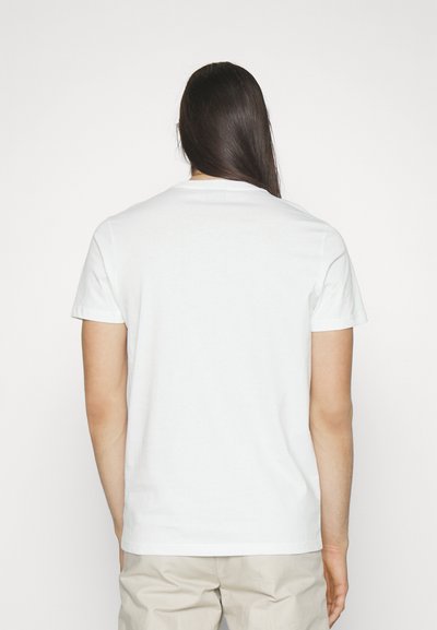 Bílý bavlněný tričko s kulatým výstřihem a krátkými rukávy, hladká textura a minimalistický design, z pohledu zezadu.