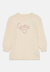 Maglione lavorato a maglia in crema con un motivo a diamante testurizzato. Presenta un collo rotondo e maniche a sbuffo. "Guess" e cuore ricamati in rosa.
