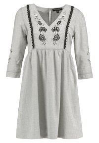 Grå linnklänning med 3/4-ärmar, V-ringning, broderad blommönster i svart och spetsdetaljer längs halsringningen och bysten.