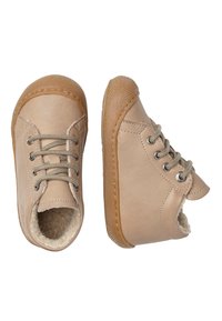 Scarpe in pelle beige con lacci, foderate in morbido pelo, punta rotonda e suole in gomma. Cuciture laterali decorative e una punta testurizzata.