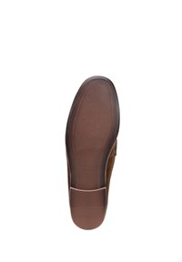 Zapato de ante marrón con una suela de goma texturizada, con una punta redondeada y un sutil logo grabado en el área del talón.