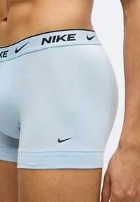 Ανοιχτό μπλε boxer briefs με μαύρο λογότυπο Nike στη μέση και το μηρό, κατασκευασμένα από μαλακό, ελαστικό ύφασμα σχεδιασμένο για άνεση.