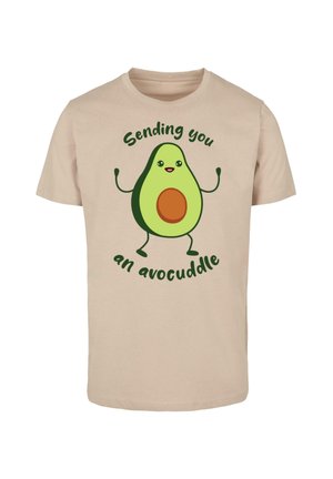 Bežist puuvillane T-särk, millel on koomiline avokaado kätega, pruun kivi ja tekst "Saadan sulle avokalli" roheliselt.