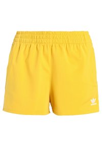 Yellow athletic shorts made of lightweight fabric with an elastic waistband, featuring side pockets and a white Adidas logo on the hem.