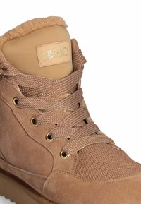 Brune høj-top sneakers i suede og mesh med en fluffy tan krave, guld hardware og teksturerede snørebånd. Brandetiket synlig på tungen.