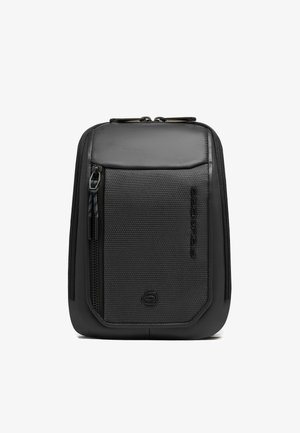 Kompakte schwarze Reisetasche mit strukturiertem Frontfach, Reißverschluss und dem Piquadro-Logo, das im unteren und seitlichen Bereich geprägt ist.