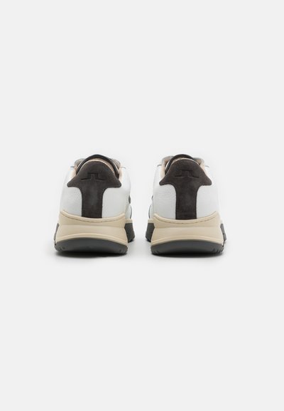 White sneakers featuring a smooth leather upper with gray suede accents, a beige midsole, and black rubber outsole.