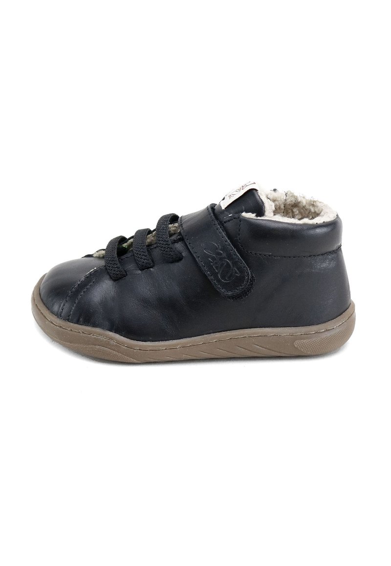 Zapatilla de cuero negra con un suave forro beige, sistema de cierre con cordones y tiras de Velcro ajustables. Cuenta con una suela de goma con un agarre texturizado.