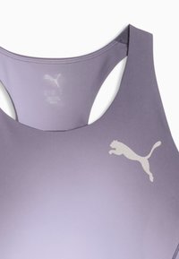 Μωβ αθλητικό σουτιέν με λευκό λογότυπο Puma στο μπροστινό μέρος και σχέδιο racerback ορατό στην κορυφή σε λευκό φόντο.