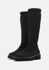 Botas negras hasta la rodilla hechas de material suave, con una suela gruesa, detalles de costura sutiles y un diseño de punta redondeada.