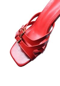 Sandalo alto in pelle rossa con tacco, caratterizzato da più cinturini, punta squadrata e due fibbie dorate. Texture liscia con finitura lucida.