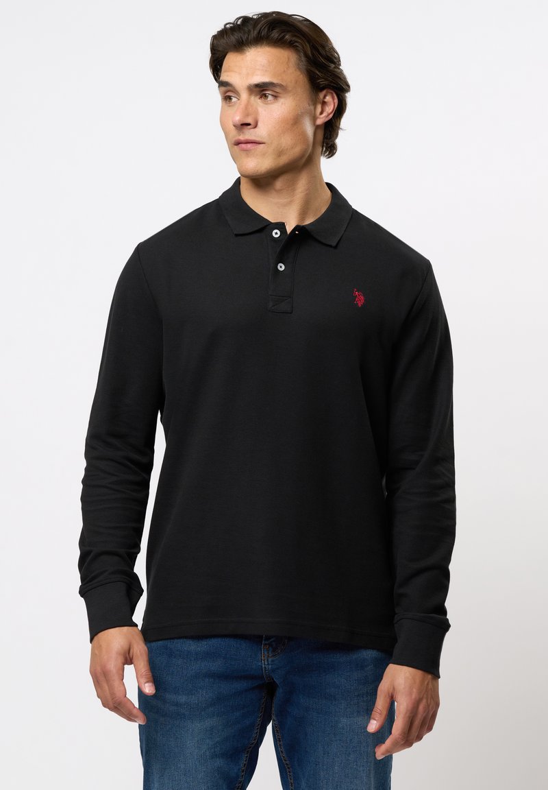 Svart langermet polo skjorte med teksturert stoff, krage med to knapper og en liten rød brodert logo på brystet.