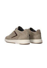 Beige Wildledersneaker mit dunkelbraunen Akzenten, runder Spitze, gepolsterter Ferse und weißer Gummisohle mit strukturiertem Profilmuster.