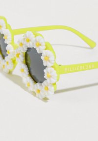 Πράσινα γυαλιά ηλίου με ανθικό σχέδιο που περιλαμβάνει λευκά μαργαρίτα με κίτρινα κέντρα, σκουρόχρωμους φακούς και στρογγυλό σχήμα. Όνομα μάρκας: BILLIEBLUSH.