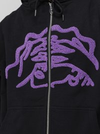 Zwarte zip-up hoodie met een textuur in paarse grafische ontwerp aan de voorkant. Opvallende details zijn een zilveren rits en trekkkoord.
