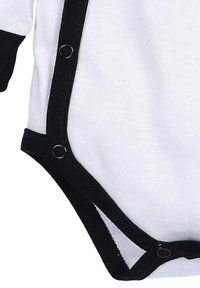 Zwart-witte baby romper, gemaakt van zacht katoen, met zwarte rand, drukknoopsluitingen aan de onderkant en lange mouwen.