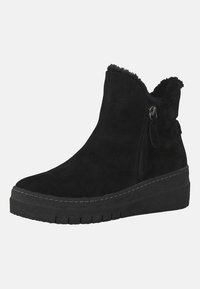 Bottines en suede noir avec une finition texturée, fermeture éclair sur le côté, doublure en fausse fourrure et semelle épaisse et texturée. Présente un design de talon en wedge.