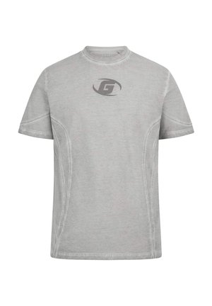 Harmaa lyhythihainen t-paita, jossa on pyöreä kaula-aukko. Paitassa on hienovarainen logo tummemmassa sävyssä ja kontrastiväriset saumat.