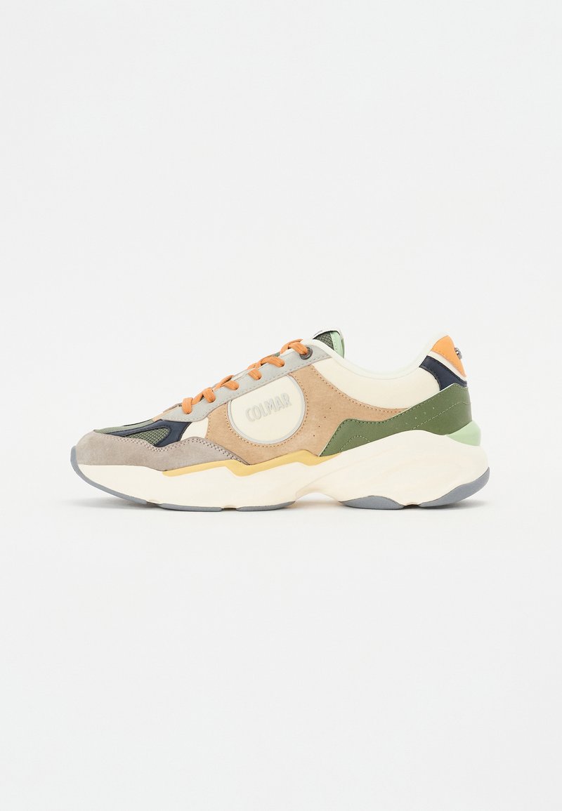 Beige, zöld és narancs kiegészítőkkel rendelkező sneaker, domború kialakítással, velúr és hálós anyagokból, valamint logóval az oldalon.