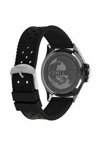 Mustast kummist rihmaga kell, millel on tekstuurse mustriga detailid, roostevabast terasest pannal ja ümmargune korpus. Tagaküljel on maailmakaardi kujundus.