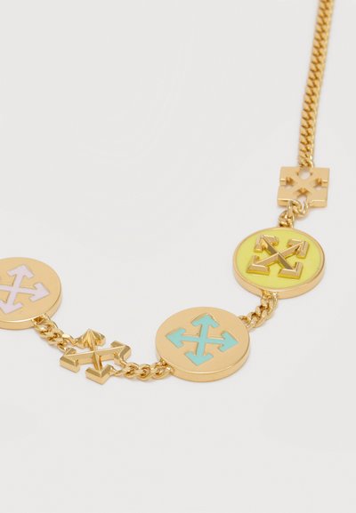 Χρυσό κολιέ με αλυσίδα και στρογγυλά μενταγιόν που έχουν πολύχρωμα βέλη σε μπλε, κίτρινο και λευκό πάνω σε ανοιχτό φόντο.