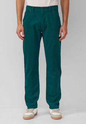 Teal katoenen chinos met een rechte pijpdesign, voorzien van zakdetails en een knoopsluiting, gecombineerd met beige sneakers.