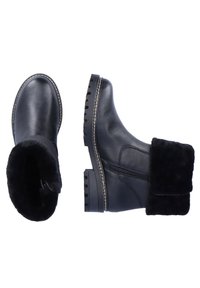 Bottines en cuir noir avec un revers en fourrure noire douce. Elles disposent d'une fermeture éclair sur le côté et d'une semelle extérieure robuste avec des coutures blanches décoratives.