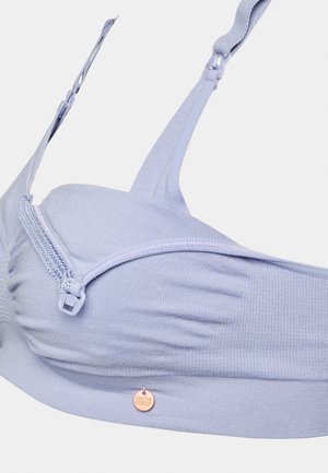 Helllila BH aus geripptem Stoff, mit Reißverschluss vorne, verstellbaren Trägern und einem kleinen metallischen Etikett. Glatte Textur über die gesamte Fläche.