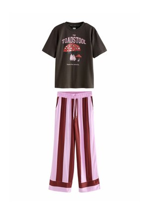Dunkelbraunes Baumwoll-T-Shirt mit rotem Pilzprint und weißem Text; rosa und burgunderfarbene gestreifte weite Hose mit elastischem Bund.