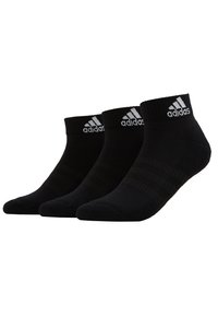 Calcetines tobilleros negros hechos de una tela suave, con puños acanalados, logo de Adidas en blanco y sutiles rayas negras en el cuerpo. Tres pares.